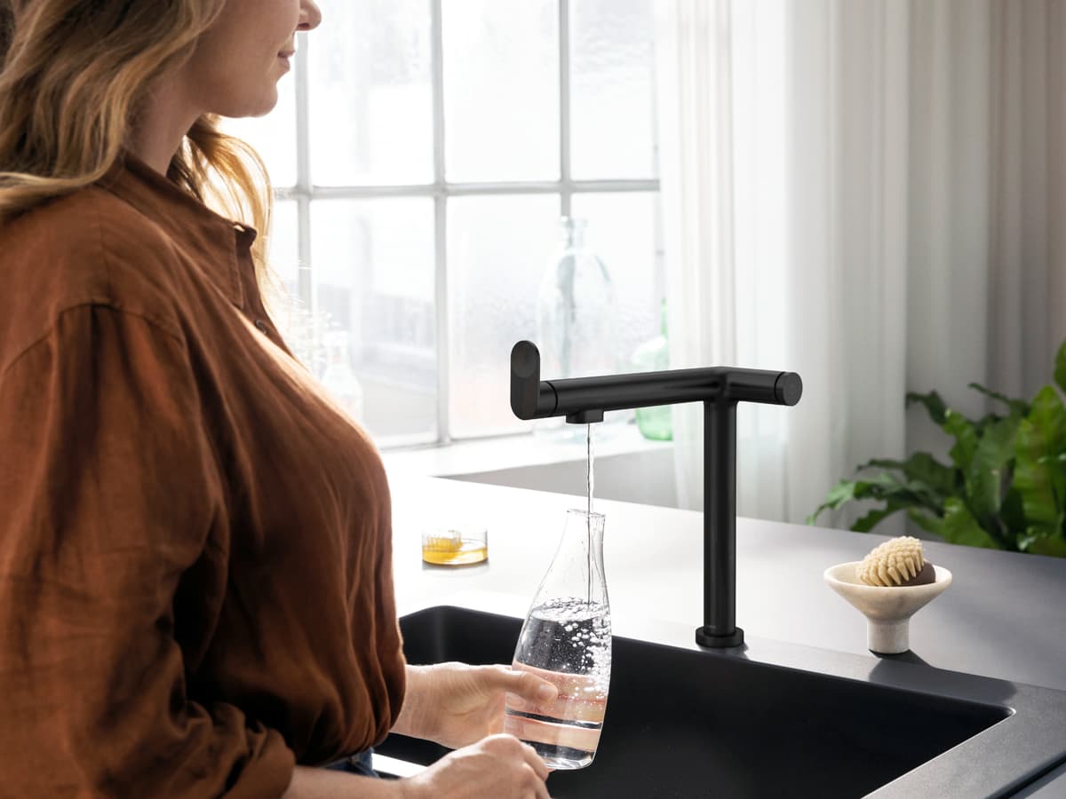 Grifería hansgrohe Aqittura M91 de diseño lineal sirviendo agua filtrada
