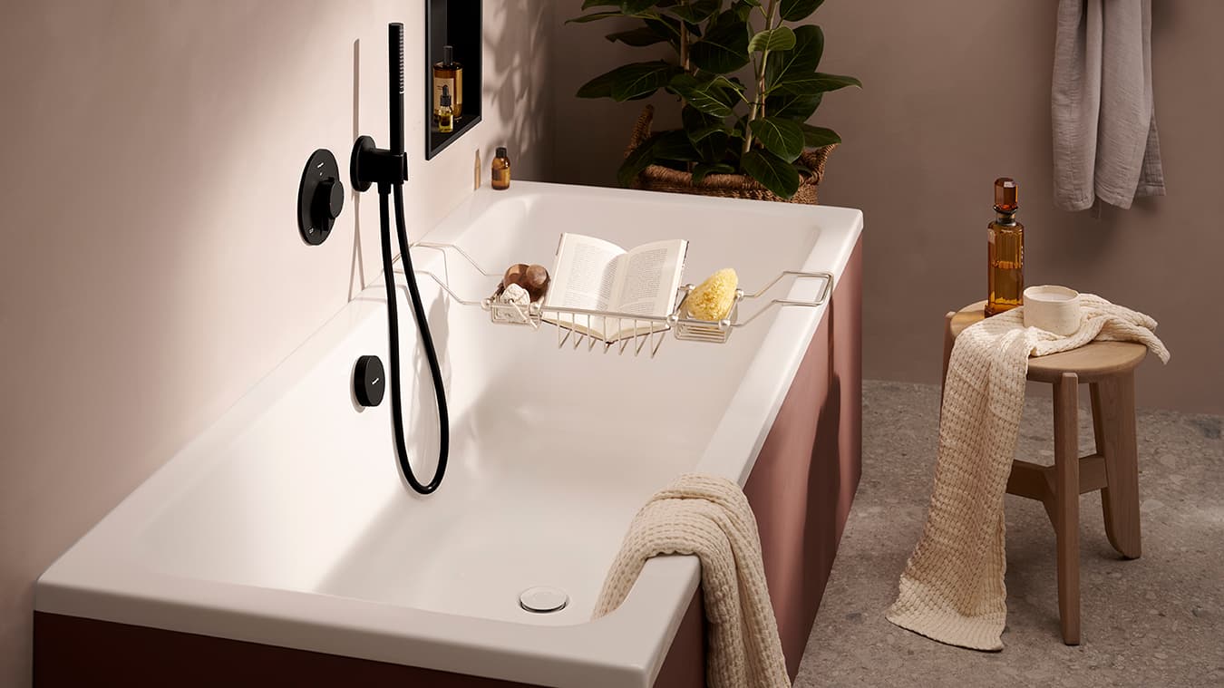 Termostato redondo hansgrohe Ecostat Comfort S en negro mate junto a la bañera