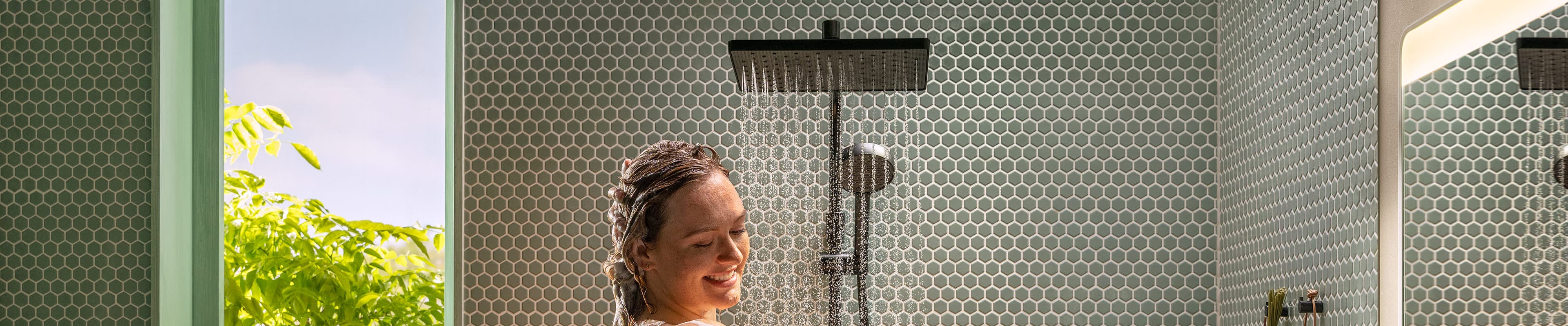 Mujer duchándose con un sistema de ducha hansgrohe Activera Q