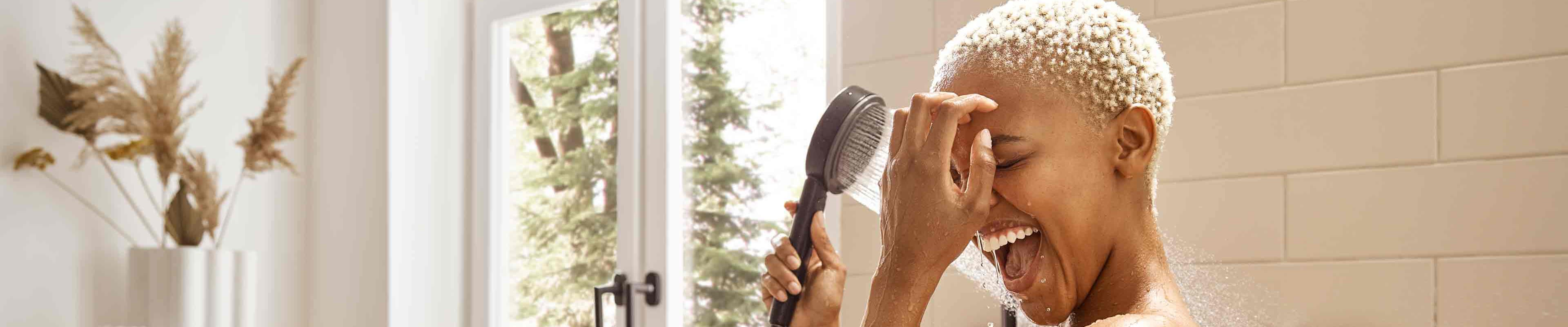 Mujer bajo una ducha fija hansgrohe Pulsify con chorro PowderRain